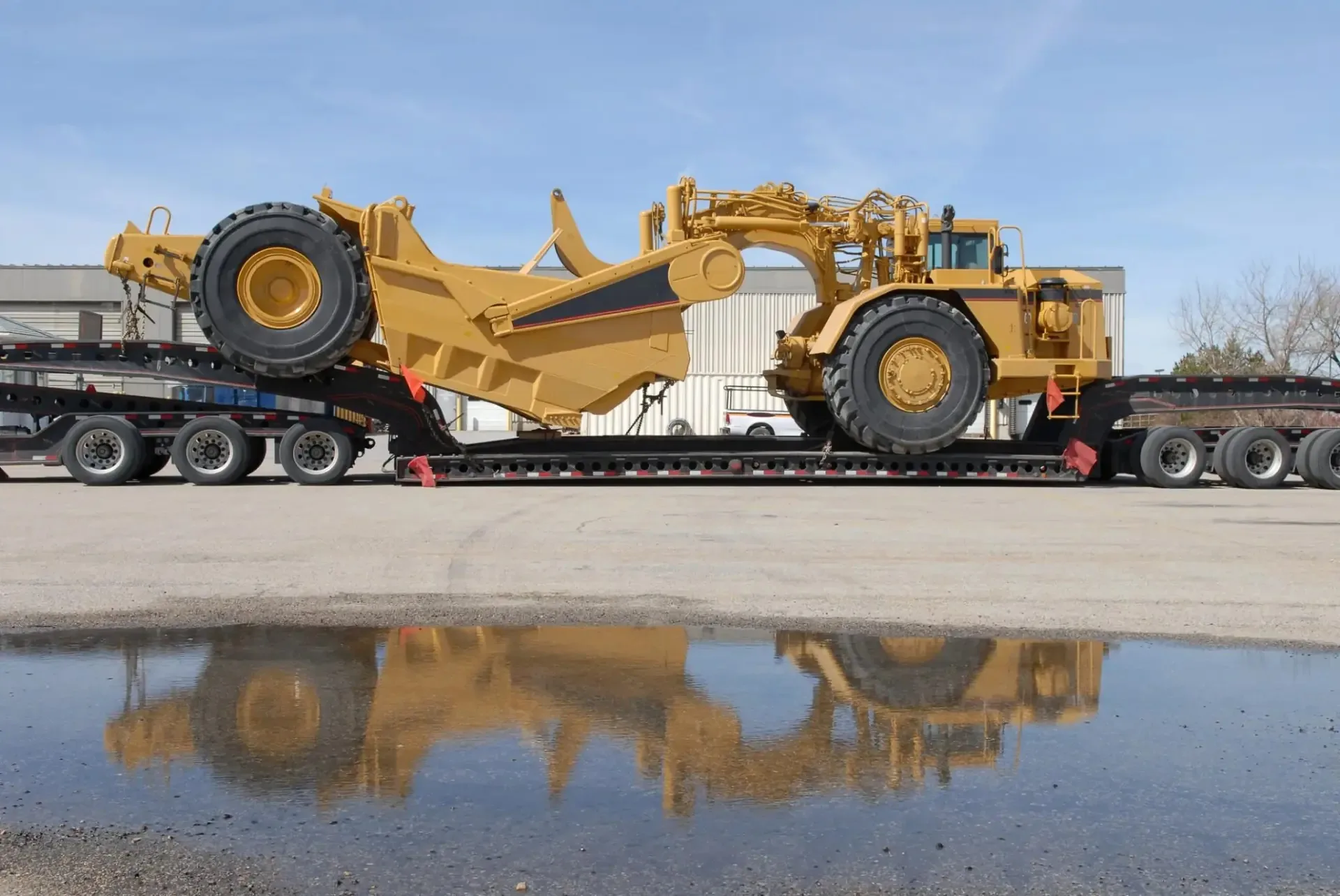 Mining scraper loaded on a low-bed semi-trailer