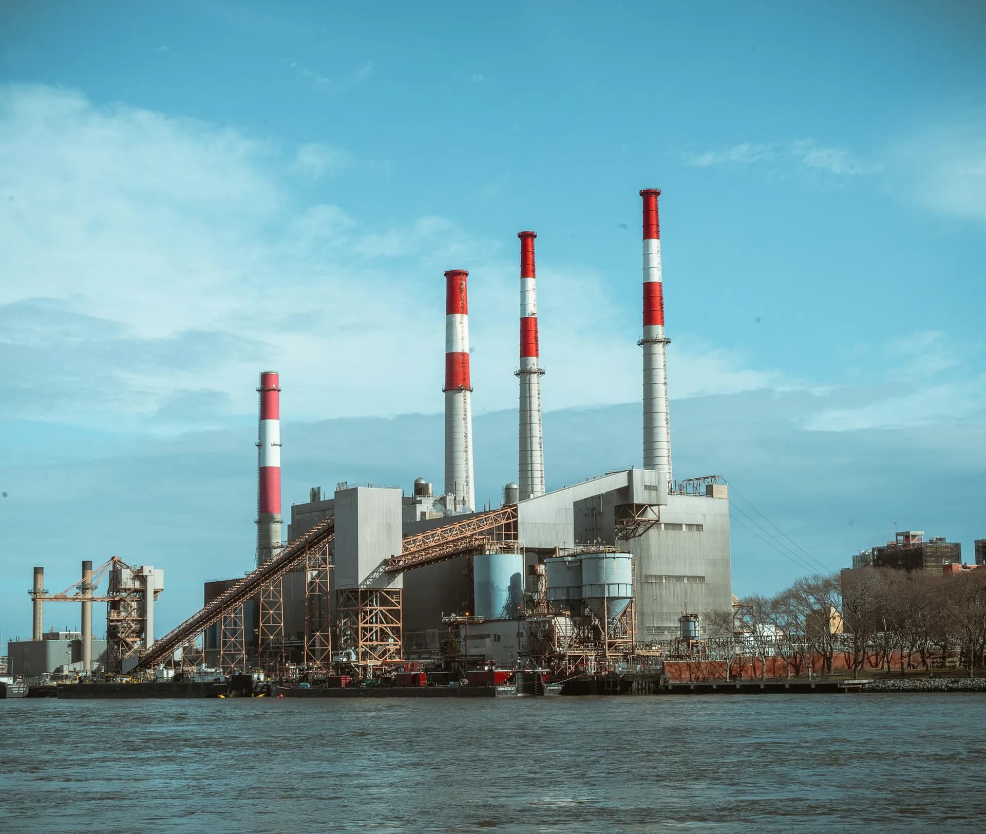 Thermal power station with tall smokestacks on a riverbank